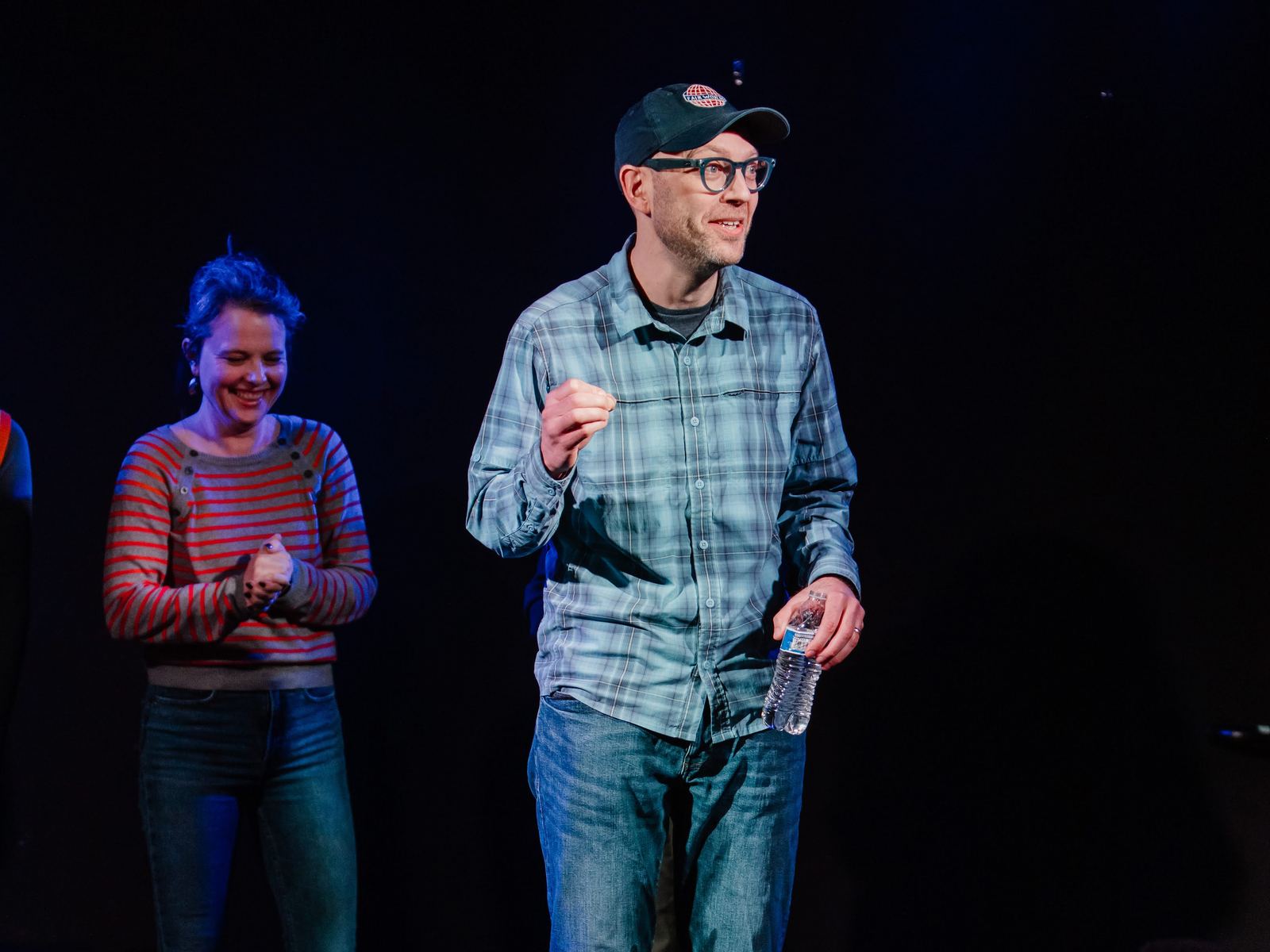 Erik on stage at Northwest Improv Fest, water bottle in hand