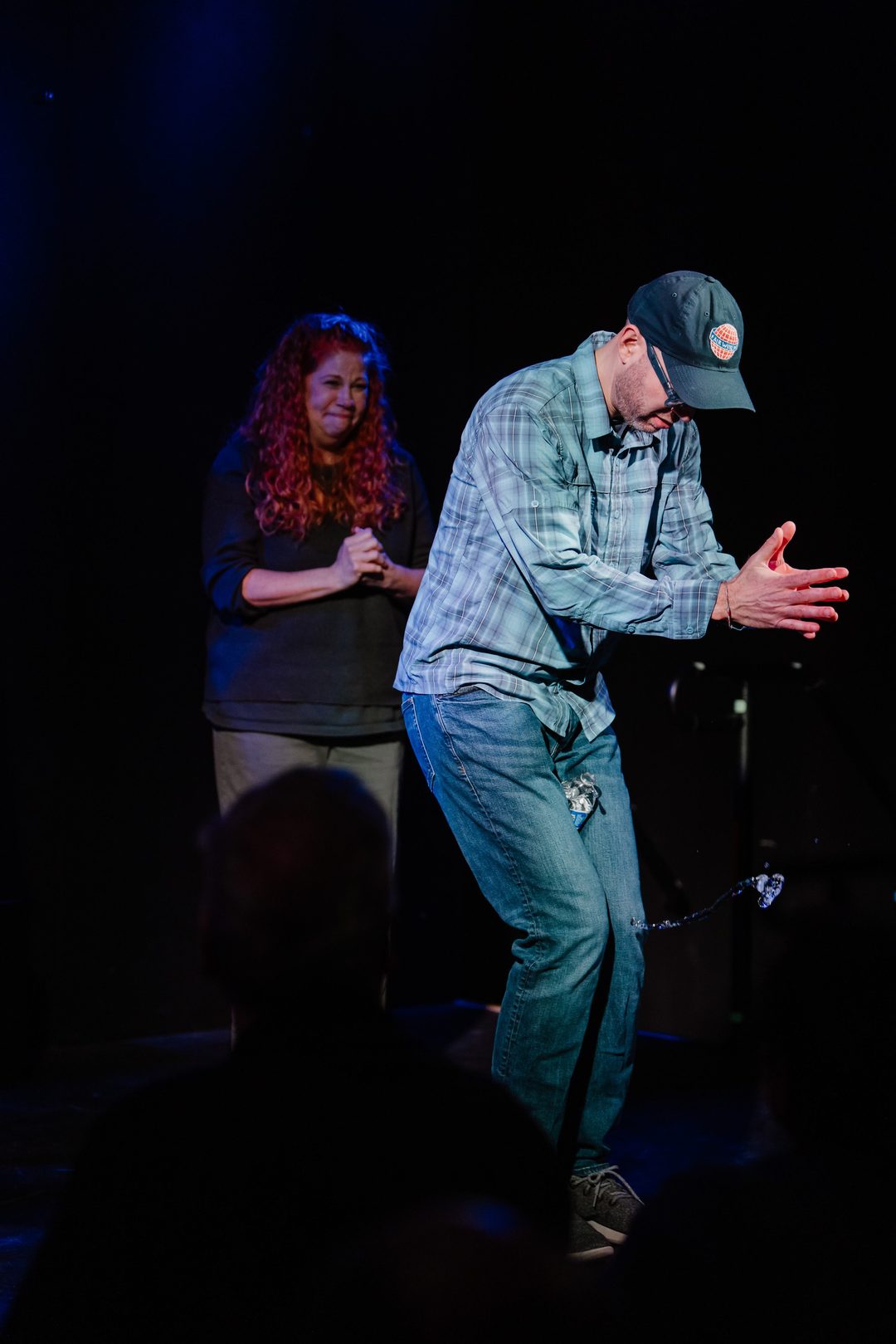 Erik reenacting the water-bottle spill on stage, water pouring from the bottle